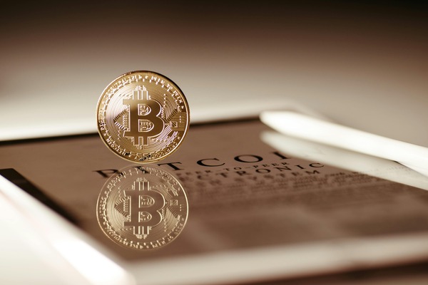 Cryptocurrency coin balanced on a tablet screen