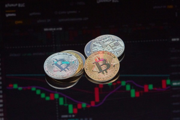 Cryptocurrency coins lying on a candlestick chart display