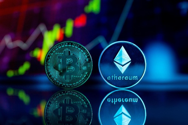 Glowing cryptocurrency coins in front of a market chart