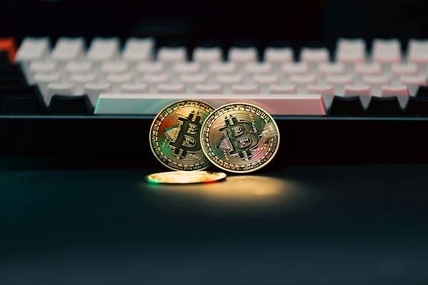 Two cryptocurrency coins in front of a keyboard