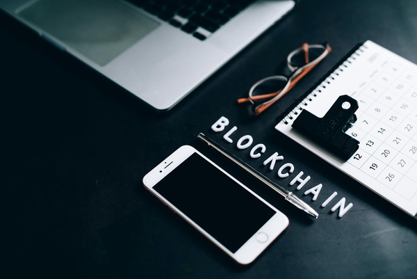 Desk with a laptop, smartphone and the word blockchain