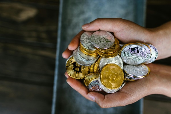Hands holding a pile of cryptocurrency coins